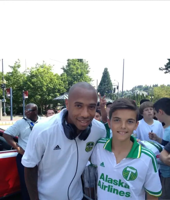 Young Medíté founder pictured with football legend Thierry Henry, reflecting the values of confidence, discipline, personal growth, and the pursuit of excellence that inspire the Medíté approach to hair regrowth and self-confidence.