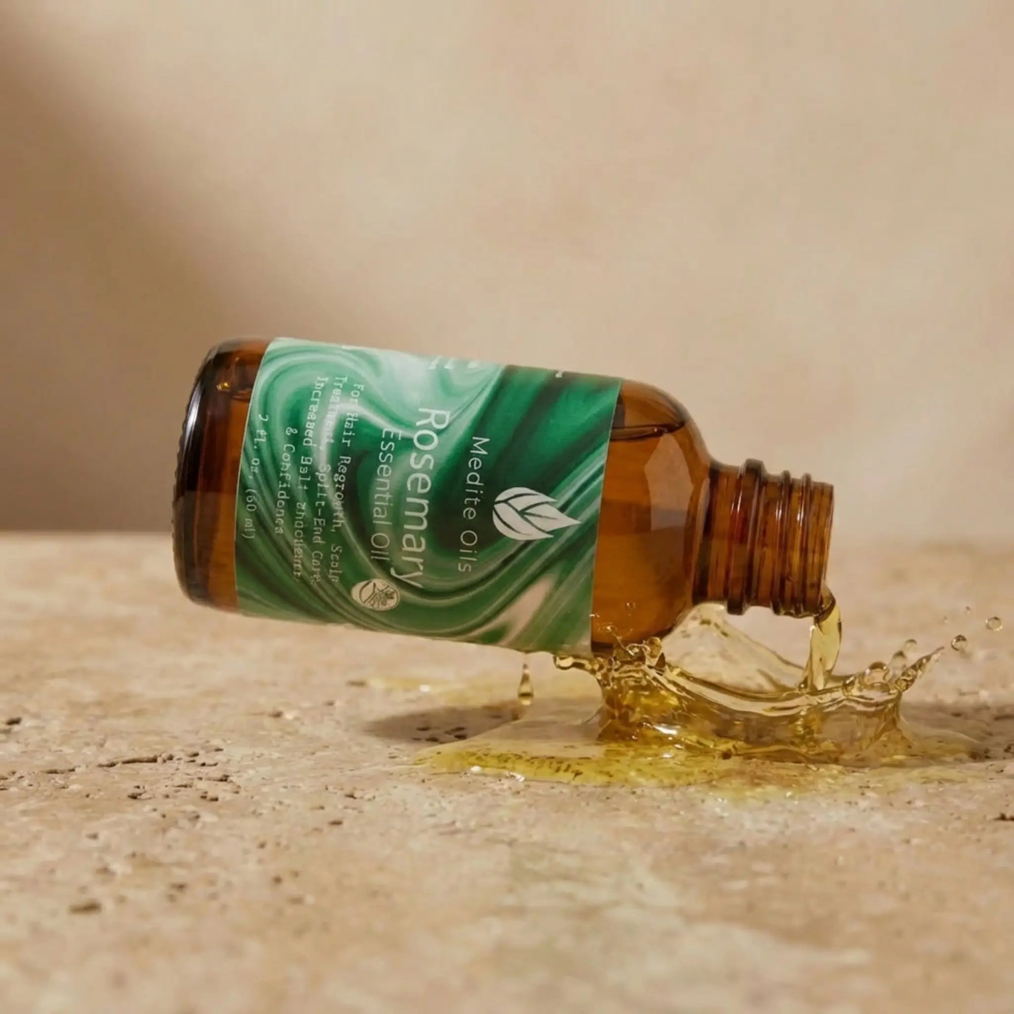 Amber bottle of Medité Rosemary Essential Oil for hair growth and scalp care pouring pure plant-based oil onto a stone surface